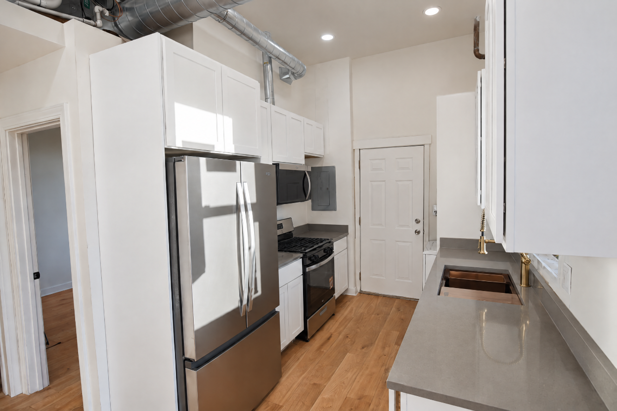 1077 W Polk #2 — kitchen with white cabinets and stainless appliances
